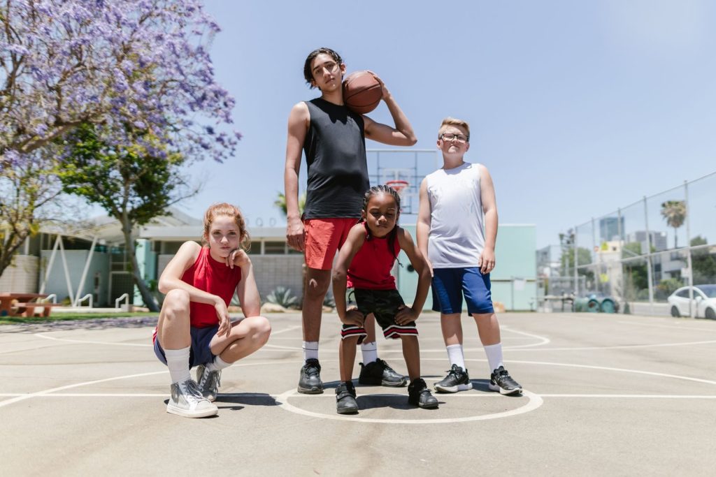 Jóvenes jugadores de baloncesto posando en una pista al aire libre
