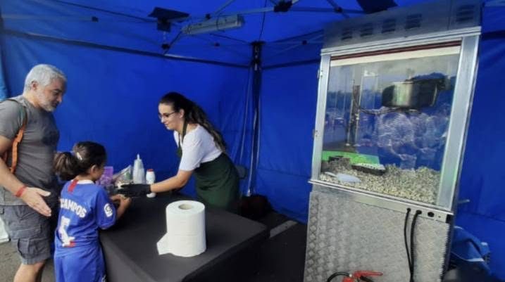 Stand con máquina de palomitas atendiendo a una familia