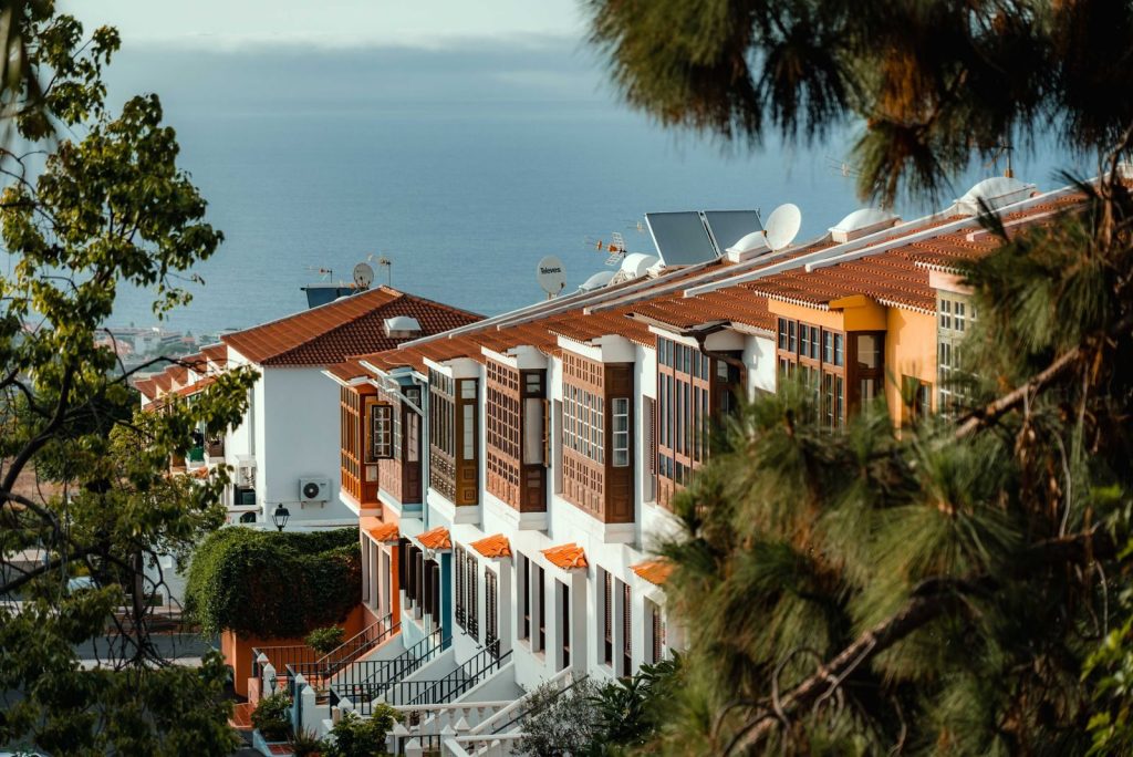 Hilera de casas canarias con balcones de madera y vistas al mar en Tenerife