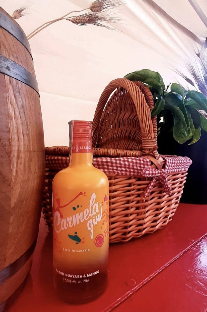 Ginebra canaria de guayaba y mango junto a una cesta de mimbre
